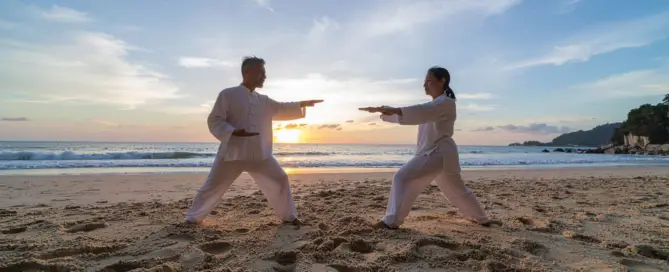 Paar übt Qi-Gong am Strand bei Sonnenuntergang – Ruhe und Balance mit TCM