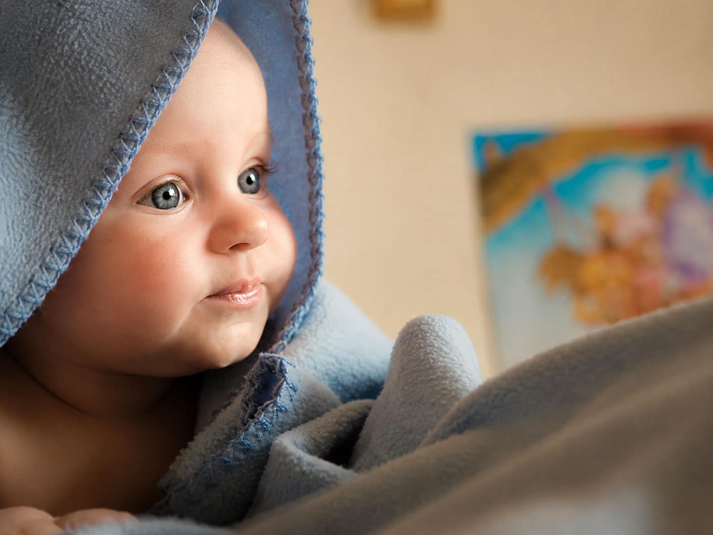 Babybild zur Kinderwunschbehandlung bei ChiMed Augsburg Baby in eine hellblaue Decke eingewickelt